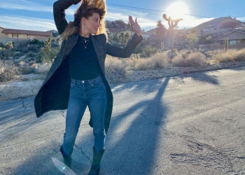 Amber Heard wearing jeans and black top with long coat