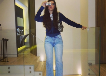 Charli D'Amelio wearing blue jeans posing with camera