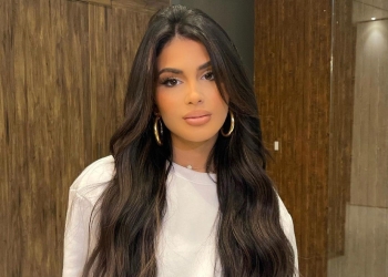 Ava Tortorici wearing a white top and golden earrings